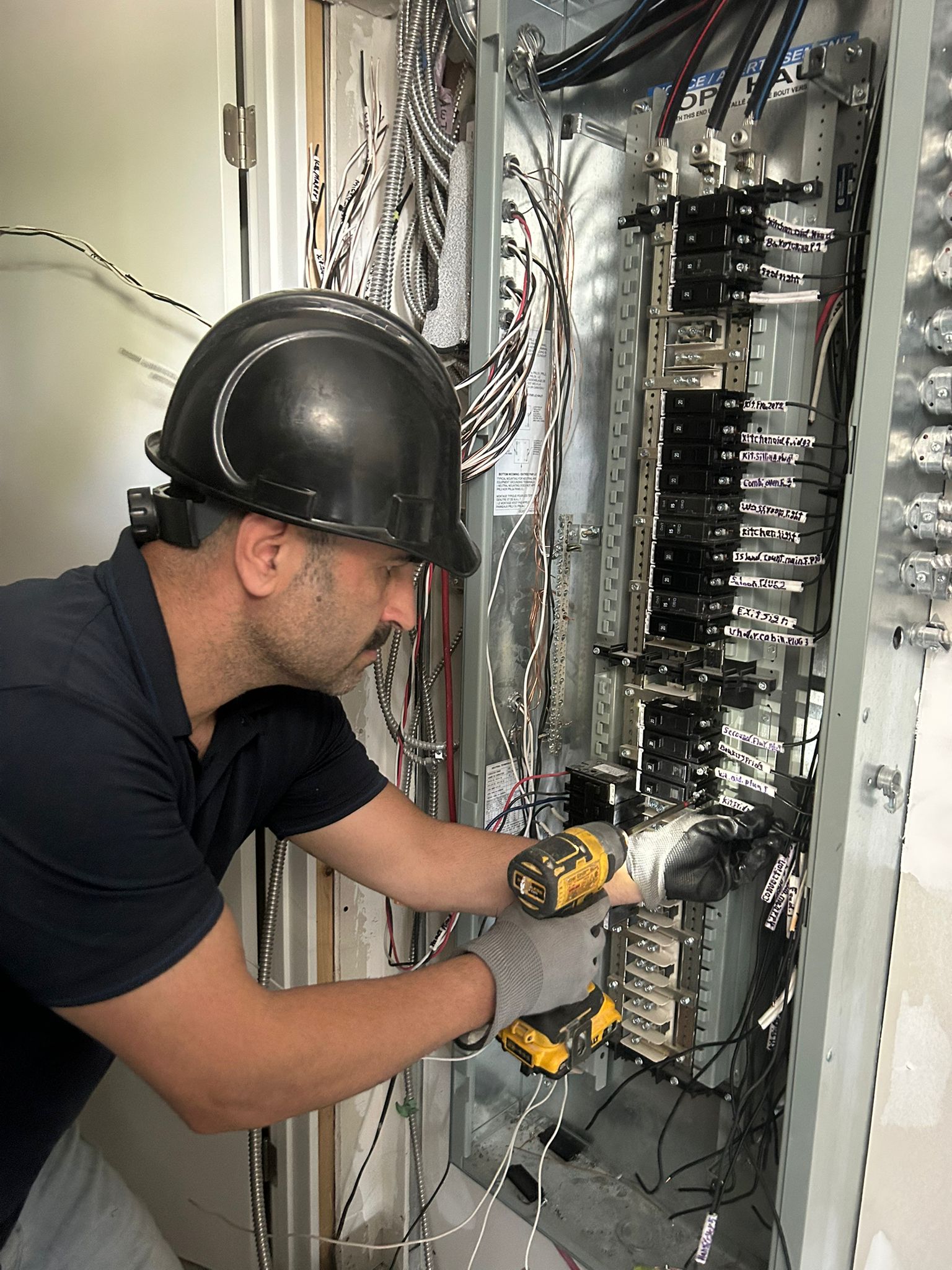 Electrician taking a live voltage reading with a multimeter during a site assessment